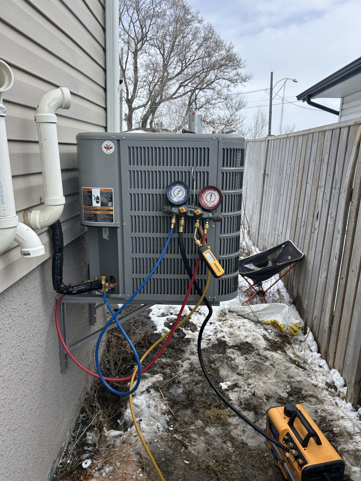 Residential HVAC system commissioning with diagnostic gauges during heat pump installation by Fire & Frost Mechanical in Saskatoon